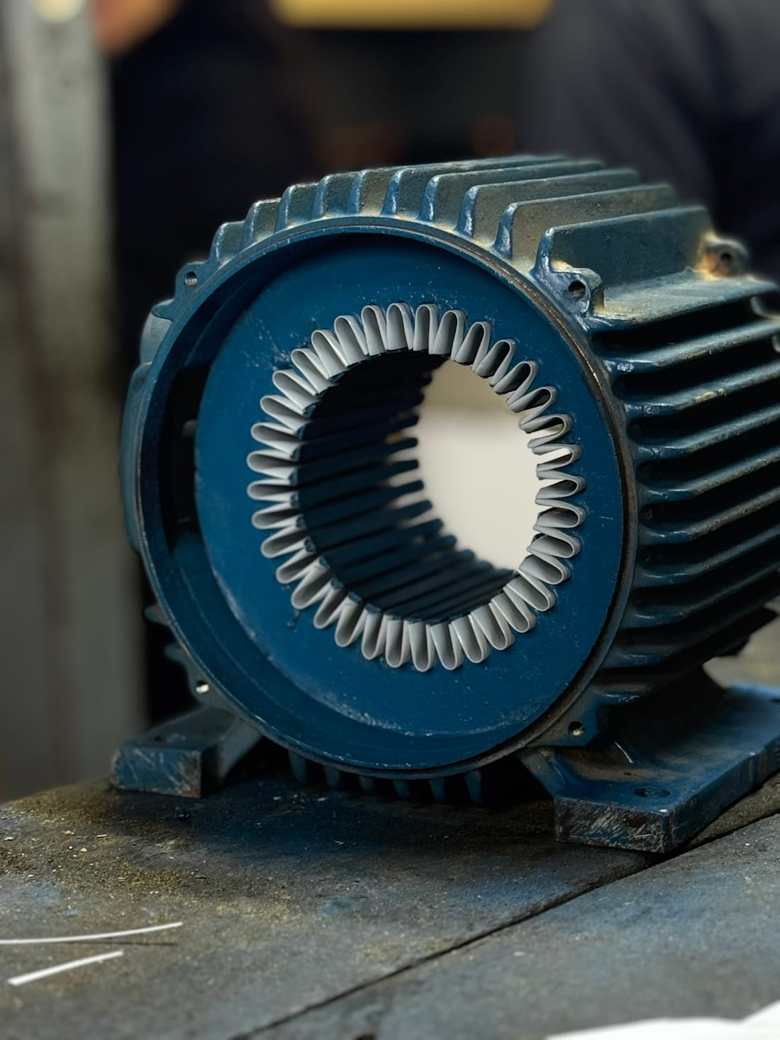 Motor elétrico aberto na bancada da Tecnomotor, com as bobinas à mostra durante o rebobinamento